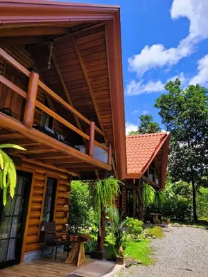 a house with a balcony on the side of it at Arenal Sweet Cabins in Fortuna