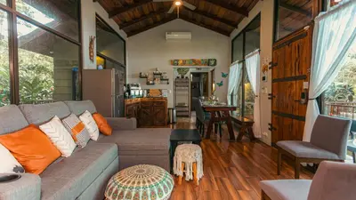 a living room with a couch and a table at Cabañas Caeli, El Congo, La Fortuna Rainforest Glass Cabin w Suite in Fortuna