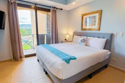 a bedroom with a large bed with a large window at Stylish 3-BR Vacation Condo with Scenic Rooftop in Jacó