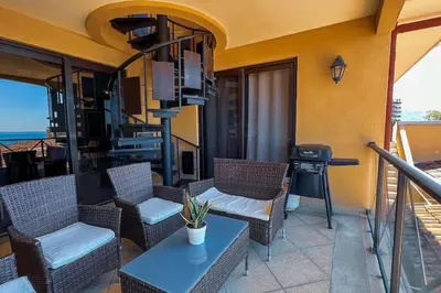 a balcony with chairs and a table and a television at Stylish 3-BR Vacation Condo with Scenic Rooftop in Jacó