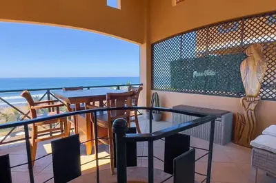 a balcony with a table and a view of the ocean at Stylish 3-BR Vacation Condo with Scenic Rooftop in Jacó