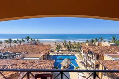 a view of a resort with a swimming pool and the ocean at Stylish 3-BR Vacation Condo with Scenic Rooftop in Jacó