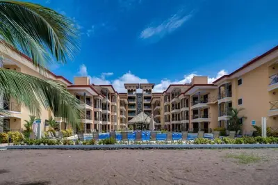 a view of a resort with a pool and palm trees at Stylish 3-BR Vacation Condo with Scenic Rooftop in Jacó
