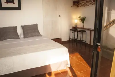 a bedroom with a bed and a table in a room at Sol Pacifico Lodge in Cascajal