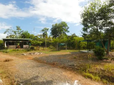 a dirt road next to a house with a playground at Kocorica in Parrita