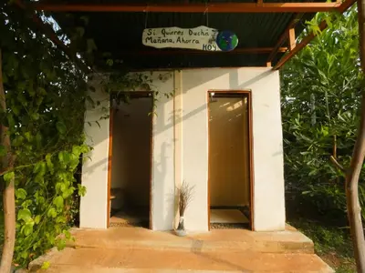 a small building with two doors and a plant in a vase at Kocorica in Parrita