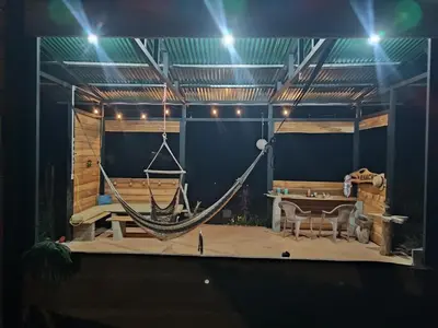 a stage with a hammock and a table and a tableablish at Kocorica in Parrita