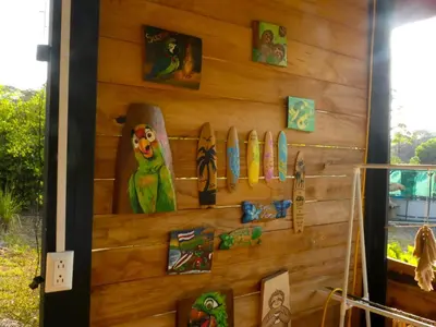 a wall with surfboards and pictures on it at Kocorica in Parrita