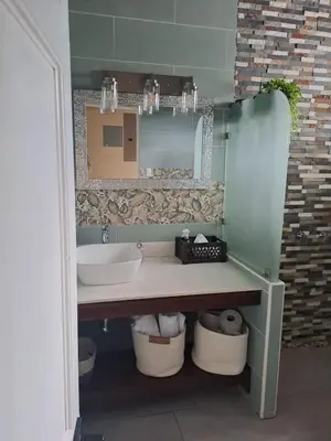 a bathroom with a sink and a mirror at House Monstera Arenal in Agua Azul