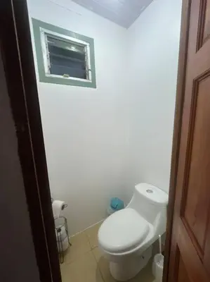 a white bathroom with a toilet and a window at Trailer House in Vara Blanca