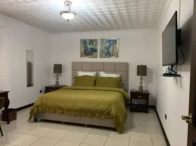 a bedroom with a bed and a flat screen tv at Luxury House near to Juan Sant. Airport, Alajuela. in Alajuela City