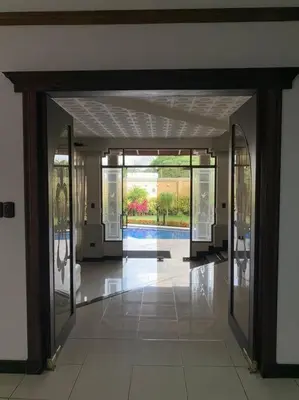 an open hallway with glass doors in a building at Luxury House near to Juan Sant. Airport, Alajuela. in Alajuela City
