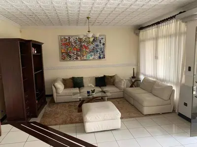 a living room with a couch and a table at Luxury House near to Juan Sant. Airport, Alajuela. in Alajuela City