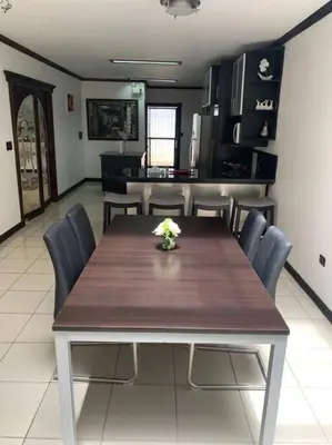 a dining room with a wooden table and chairs at Luxury House near to Juan Sant. Airport, Alajuela. in Alajuela City