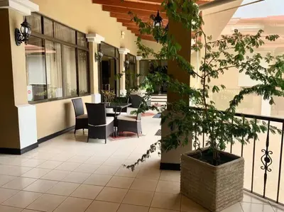 a lobby with chairs and a table in a building at Luxury House near to Juan Sant. Airport, Alajuela. in Alajuela City