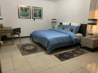 a bedroom with a blue bed and a desk at Luxury House near to Juan Sant. Airport, Alajuela. in Alajuela City