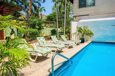 a pool with lounge chairs next to a house at Casa Corona Del Mar Tamarindo in Tamarindo