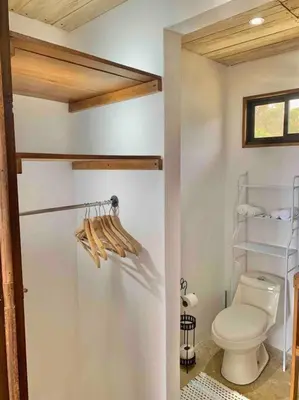 a bathroom with a white toilet and a refrigerator at Cotinga Nest - King Bed, Ocean View in San Pedrillo