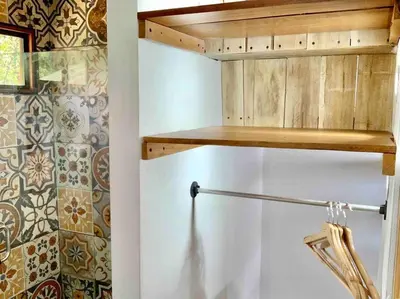 a kitchen with a wooden shelf on top of a refrigerator at Cotinga Nest - King Bed, Ocean View in San Pedrillo