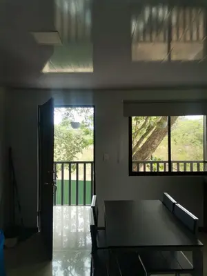 a dining room with a table and a balcony at Bee in Veintisiete de Abril