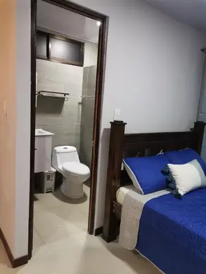a bedroom with a bed and a toilet and a bathroom at Bee in Veintisiete de Abril