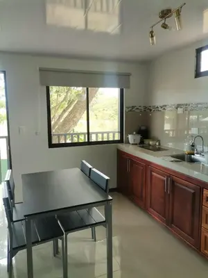 a large kitchen with a table and a window at Bee in Veintisiete de Abril