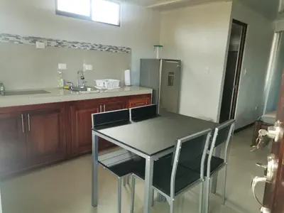 a kitchen with a table and chairs and a refrigerator at Bee in Veintisiete de Abril