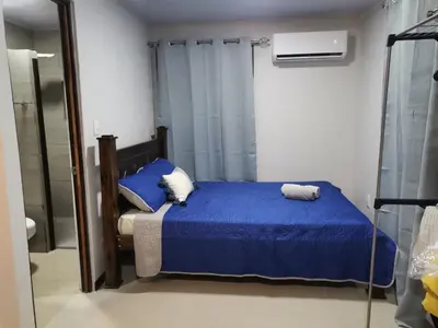a bedroom with a blue bed and a shower at Bee in Veintisiete de Abril