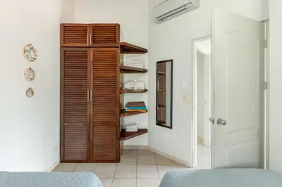 a bedroom with a wooden closet in a room at Pura Armonia Condo with Outdoor Patio in Coco
