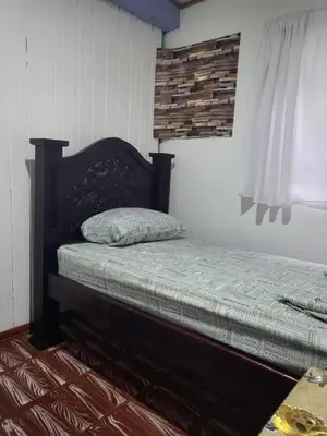 a bedroom with a bed with a pillow on it at Downtown Montezuma Hostel in Montezuma