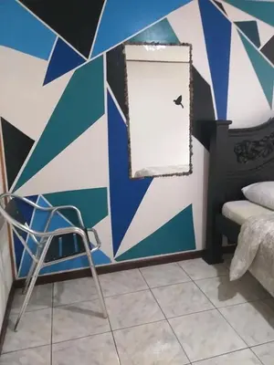 a room with a blue and white wall with a chair at Downtown Montezuma Hostel in Montezuma