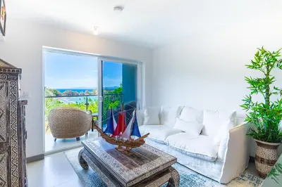 a living room with a white couch and a table at Deluxe Apt with Ocean View & Beach Access only 1 hour drive from San Jose in Puntarenas