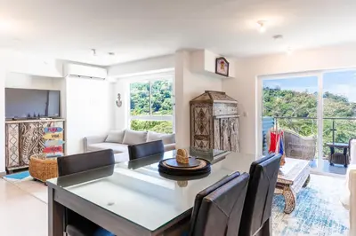a living room with a table and chairs at Deluxe Apt with Ocean View & Beach Access only 1 hour drive from San Jose in Puntarenas