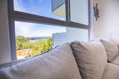 a couch sitting in front of a large window at Deluxe Apt with Ocean View & Beach Access only 1 hour drive from San Jose in Puntarenas