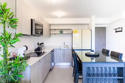 a kitchen with a counter and a table in it at Deluxe Apt with Ocean View & Beach Access only 1 hour drive from San Jose in Puntarenas