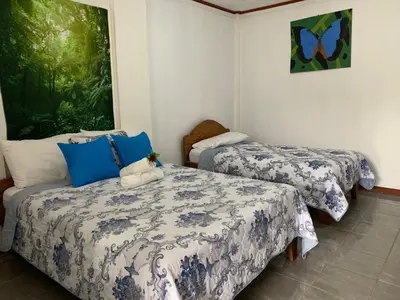 a room with two beds with blue and white sheets at Globi Lodge #6 in Monteverde Costa Rica