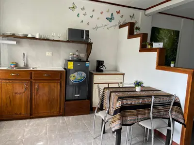 a kitchen with a table and a sink and a refrigerator at Globi Lodge #6 in Monteverde Costa Rica