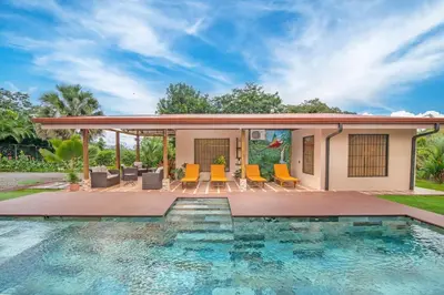 a house with a swimming pool next to a house at Casa Oasis La Fortuna Private Pool AC & WiFi 100 mbps in San Francisco