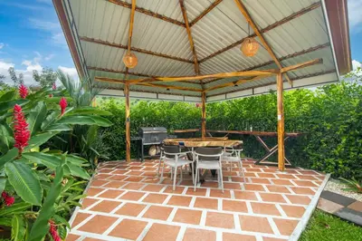 a patio with a table and chairs under a pavilion at Casa Oasis La Fortuna Private Pool AC & WiFi 100 mbps in San Francisco
