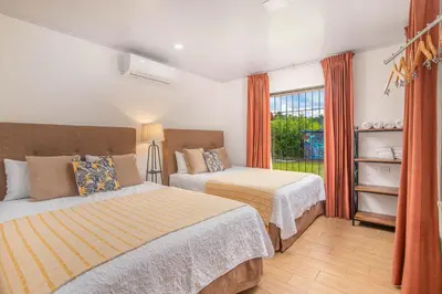 a bedroom with two beds and a window at Casa Oasis La Fortuna Private Pool AC & WiFi 100 mbps in San Francisco