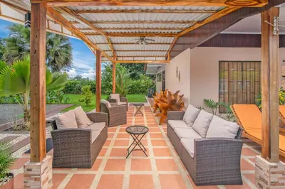 an outdoor patio with wicker furniture and a pergola at Casa Oasis La Fortuna Private Pool AC & WiFi 100 mbps in San Francisco