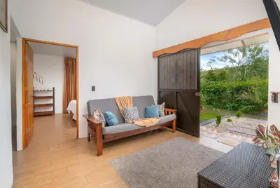 a living room with a couch and a sliding glass door at Casa Oasis La Fortuna Private Pool AC & WiFi 100 mbps in San Francisco