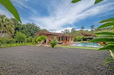 a home with a swimming pool and a house at Casa Oasis La Fortuna Private Pool AC & WiFi 100 mbps in San Francisco