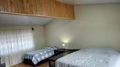 a bedroom with a bed and a table and a window at Persea Inn & Restaurante Toro Careto in El Copey