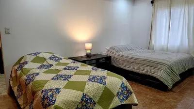 a bedroom with two beds and a lamp on a table at Persea Inn & Restaurante Toro Careto in El Copey