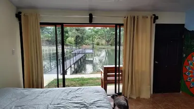 a bedroom with a bed and a view of a river at Persea Inn & Restaurante Toro Careto in El Copey
