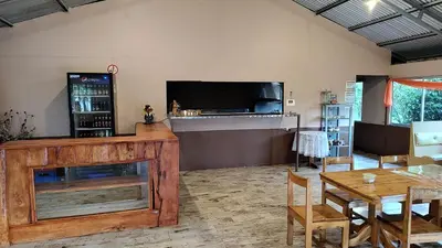 a living room with a table and a large screen tv at Persea Inn & Restaurante Toro Careto in El Copey