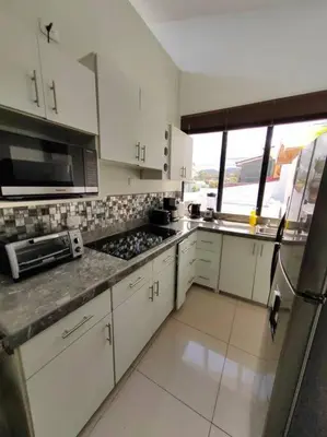 a kitchen with white cabinets and a counter top at Hotel Boutique CasAguacate Apt Morfo close to Airport in Potrerillos
