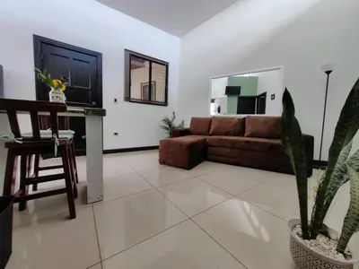 a living room with a brown couch and a tv at Hotel Boutique CasAguacate Apt Morfo close to Airport in Potrerillos