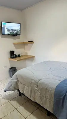 a bedroom with a bed and a tv on the wall at Nomada Monteverde in Monteverde Costa Rica